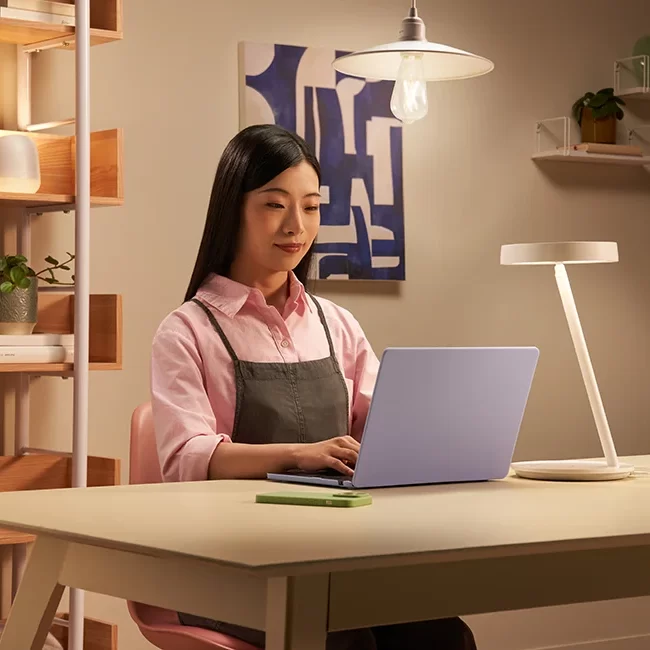 Mujer trabajando en un escritorio con iluminación moderna