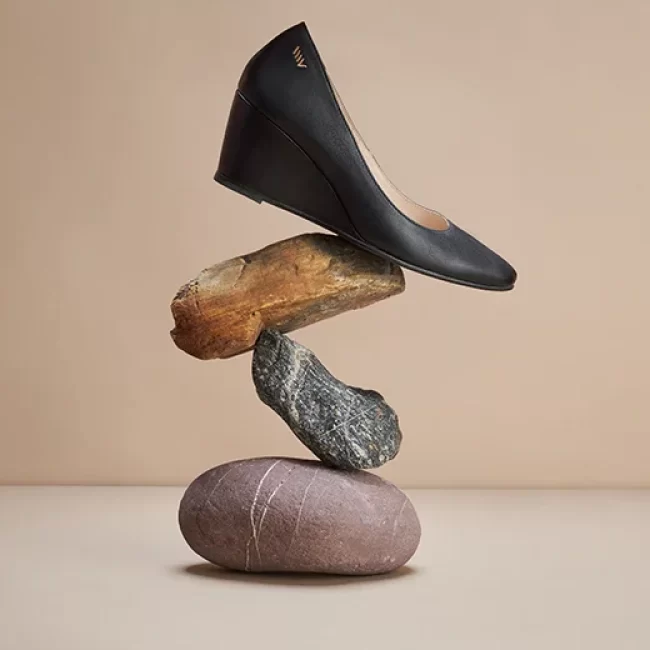 Zapato negro sobre piedras equilibradas